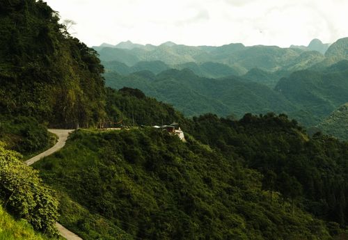 Free Lush green mountains with a winding road creating a picturesque landscape view. Stock Photo