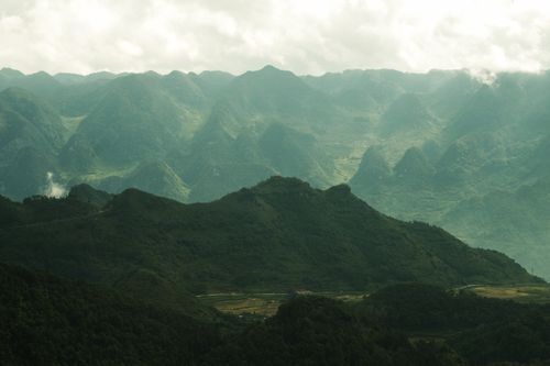 Free Stunning view of lush green mountains under a dramatic cloudy sky. Stock Photo