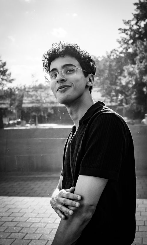 Free Black and white portrait of a young man smiling outdoors in Berlin, showcasing a lively and carefree mood. Stock Photo