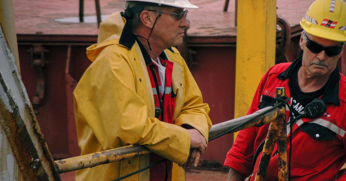 Men in safety gear managing ship operations on deck in Mackinaw City.