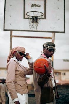 Fashionably dressed adults pose with a basketball in an urban court setting.