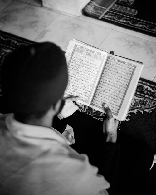 Free A person reads the Quran indoors, focusing on spiritual reflection. Stock Photo