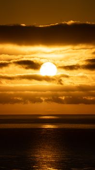 Stunning golden sunset over the ocean, creating a serene and warm atmosphere.