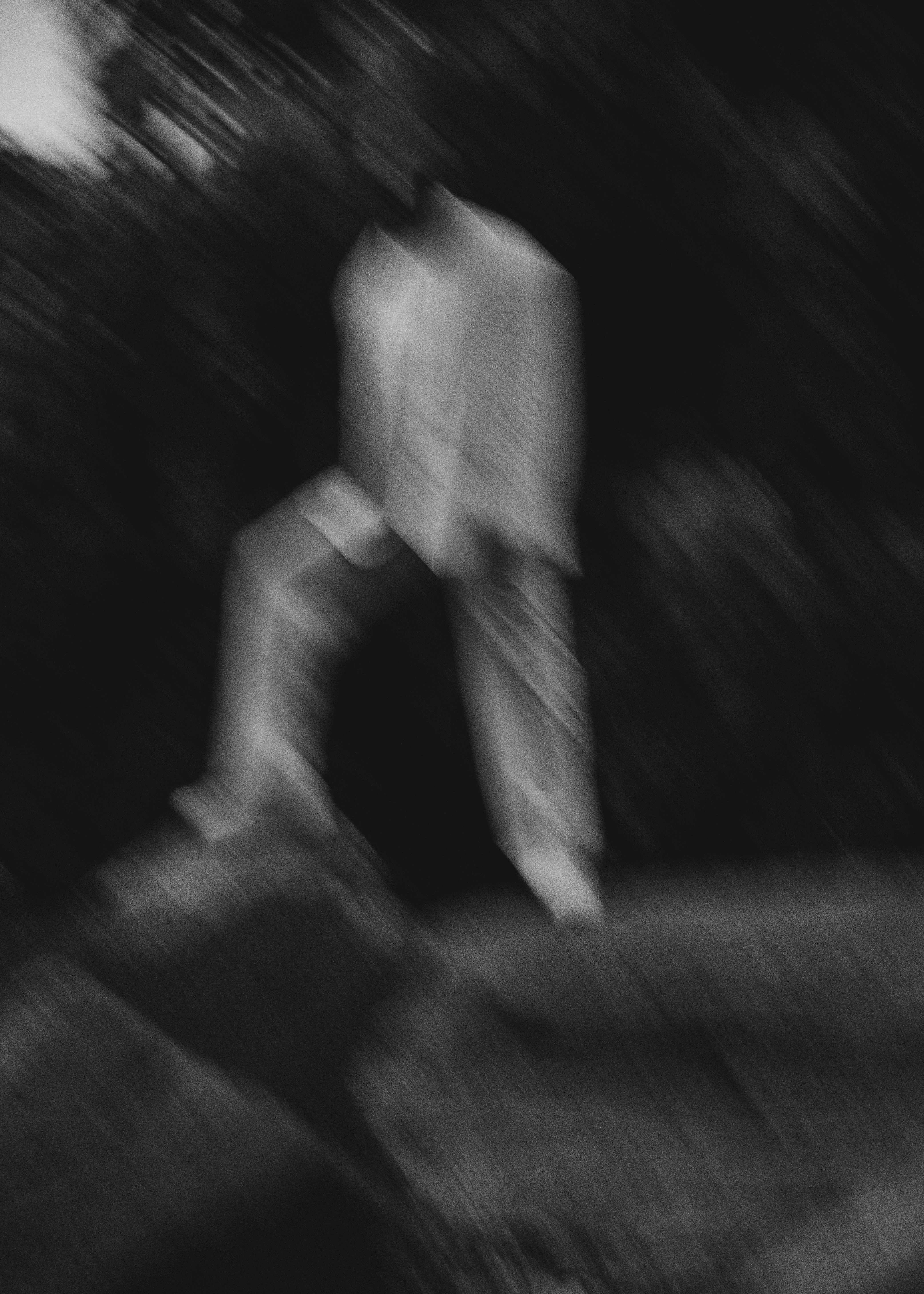 gratis Zwart-wit abstract beeld van een wazig figuur die buiten op rotsen staat. Stockfoto