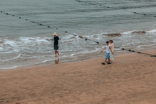 Free Calm scene of people strolling along a gentle beach shore. Stock Photo