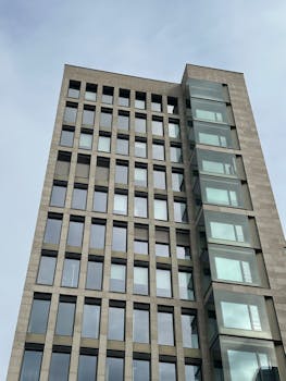 Tall modern office building with glass windows offering clear urban architecture look.