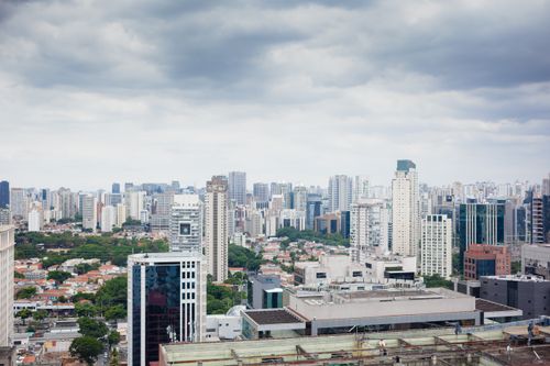 Free Aerial view of a bustling city skyline with skyscrapers under a cloudy sky. Stock Photo