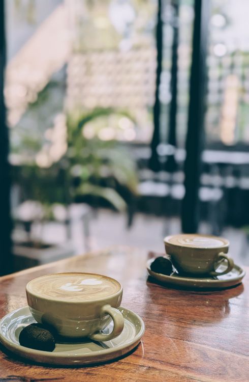 Cozy Coffee Cups in a Warm Caf Setting  Free Stock Photo