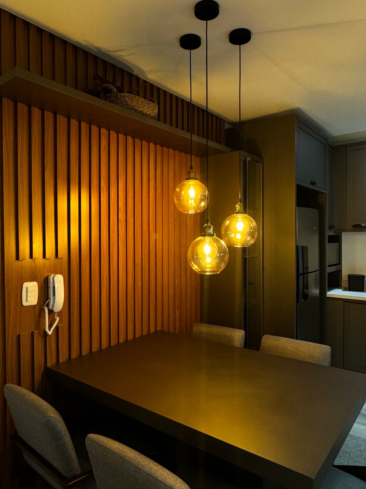 Warm dining area with pendant lighting, wooden furniture and modern decorative accents