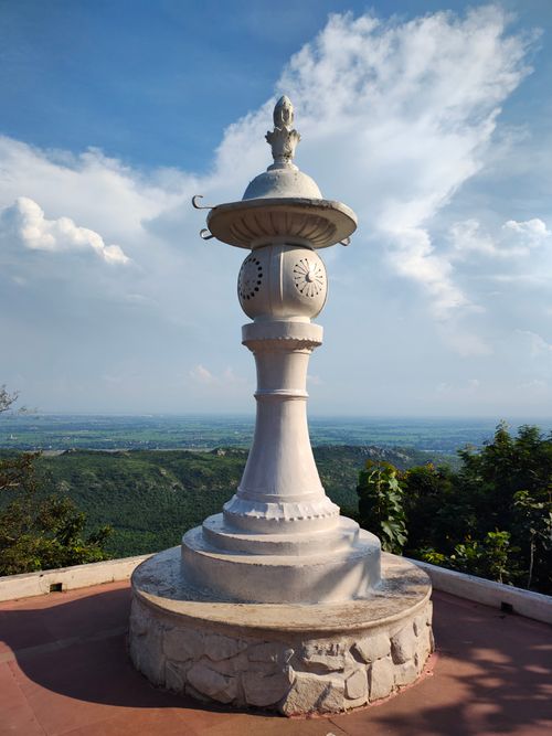 Free Elegant white stone monument overlooking a lush green valley under a bright sky. Stock Photo