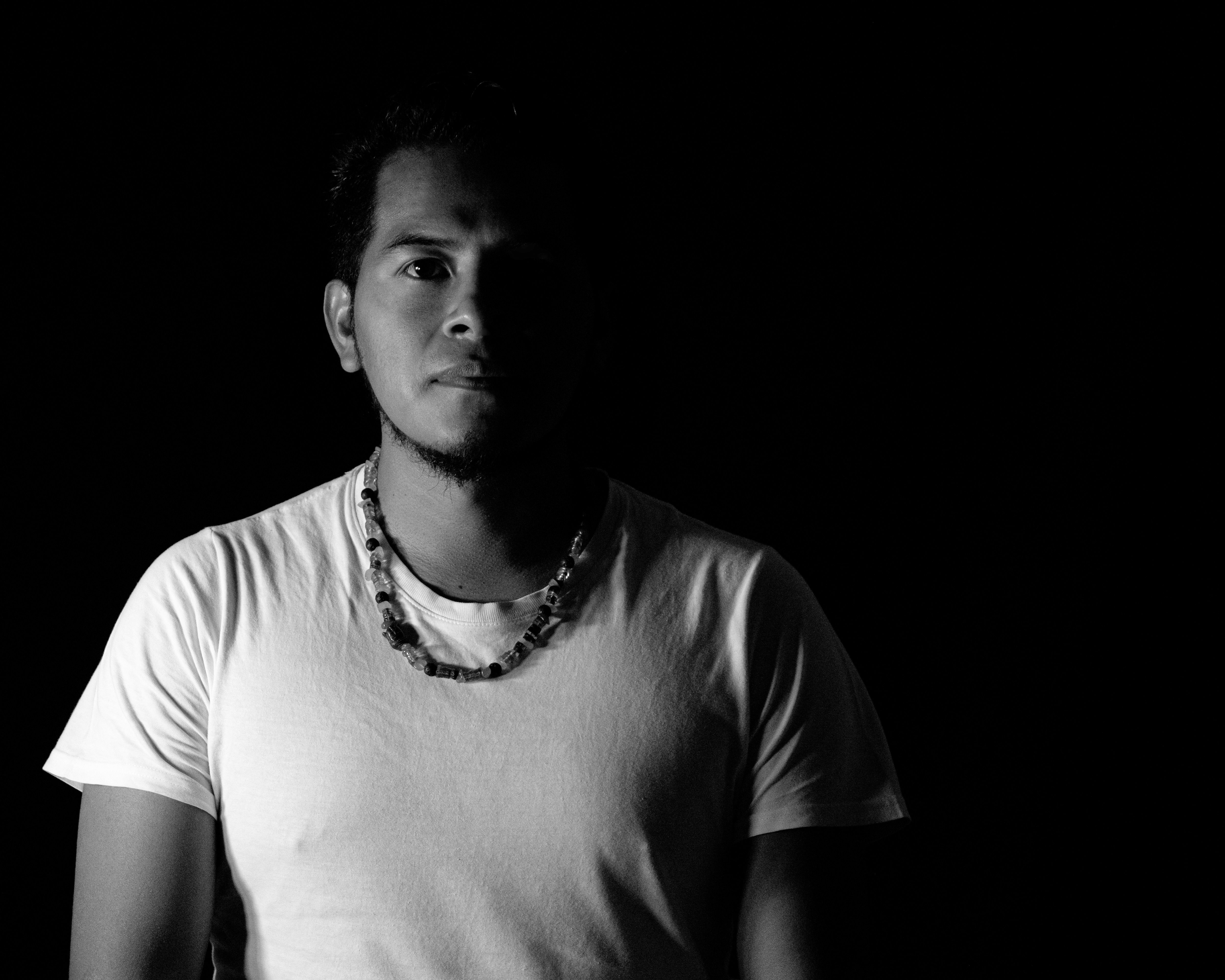 Dramatic black and white portrait of a man in silhouette with high contrast lighting.