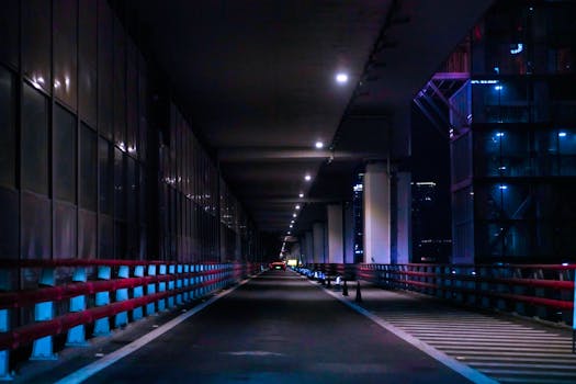 Moody night scene of Chongqing city architecture with vibrant neon lights and empty streets.