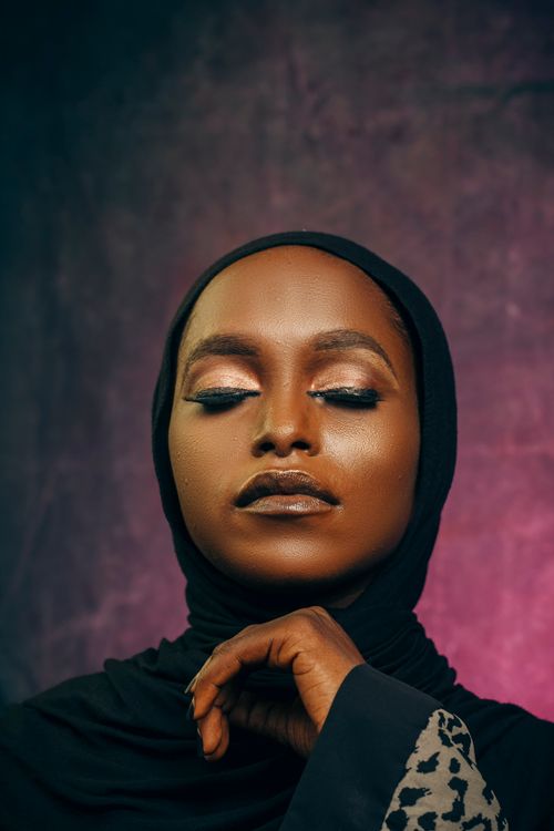 Free Artistic portrait of a woman in a hijab with eyes closed, soft lighting, and serene expression. Stock Photo