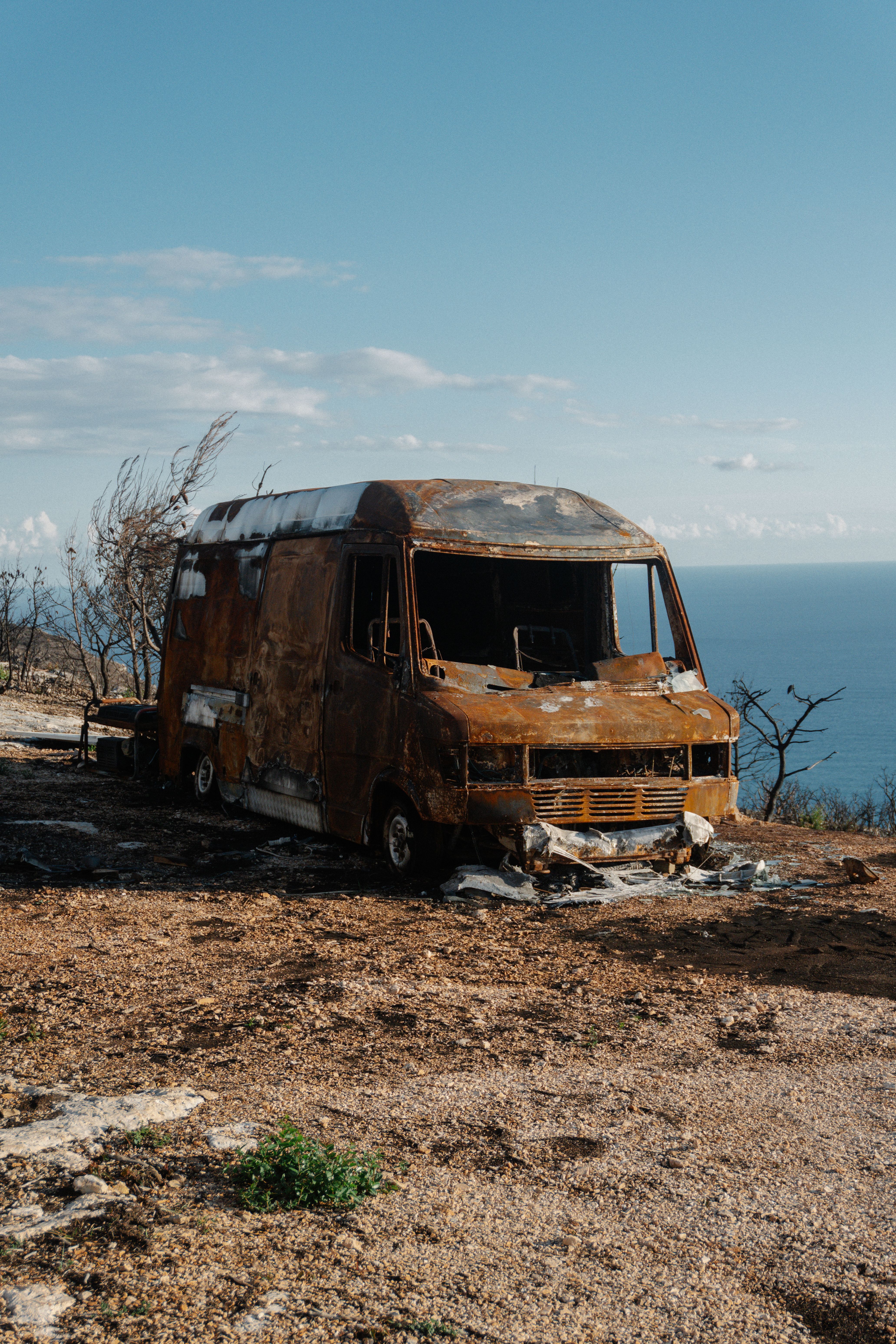 Rusty Abandoned Van Overlooking Blue Sea
