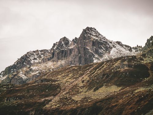 Free Snow-dusted peaks of rugged mountains in Andermatt, Switzerland during winter. Stock Photo
