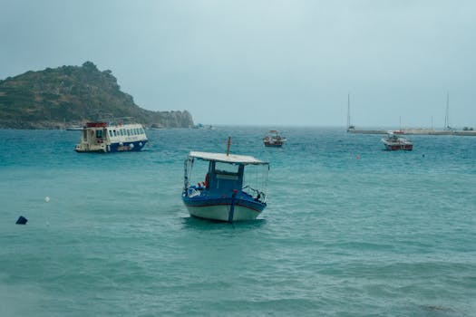 小船停泊在希腊扎金索斯海岸的清澈蓝色水域中