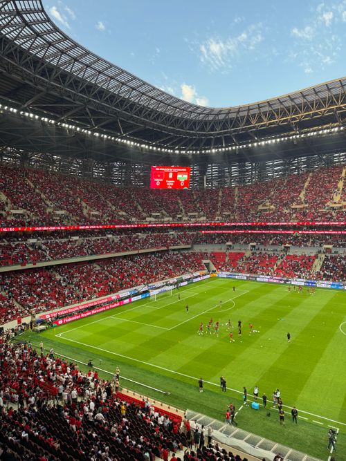 Free Packed stadium with fans and players, showcasing a lively football event under clear skies. Stock Photo