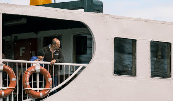 父亲和孩子在船甲板上享受平静的时刻，看着风景