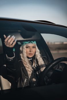 Confident woman driving a car, expressing cool and edgy style through fashion and attitude.