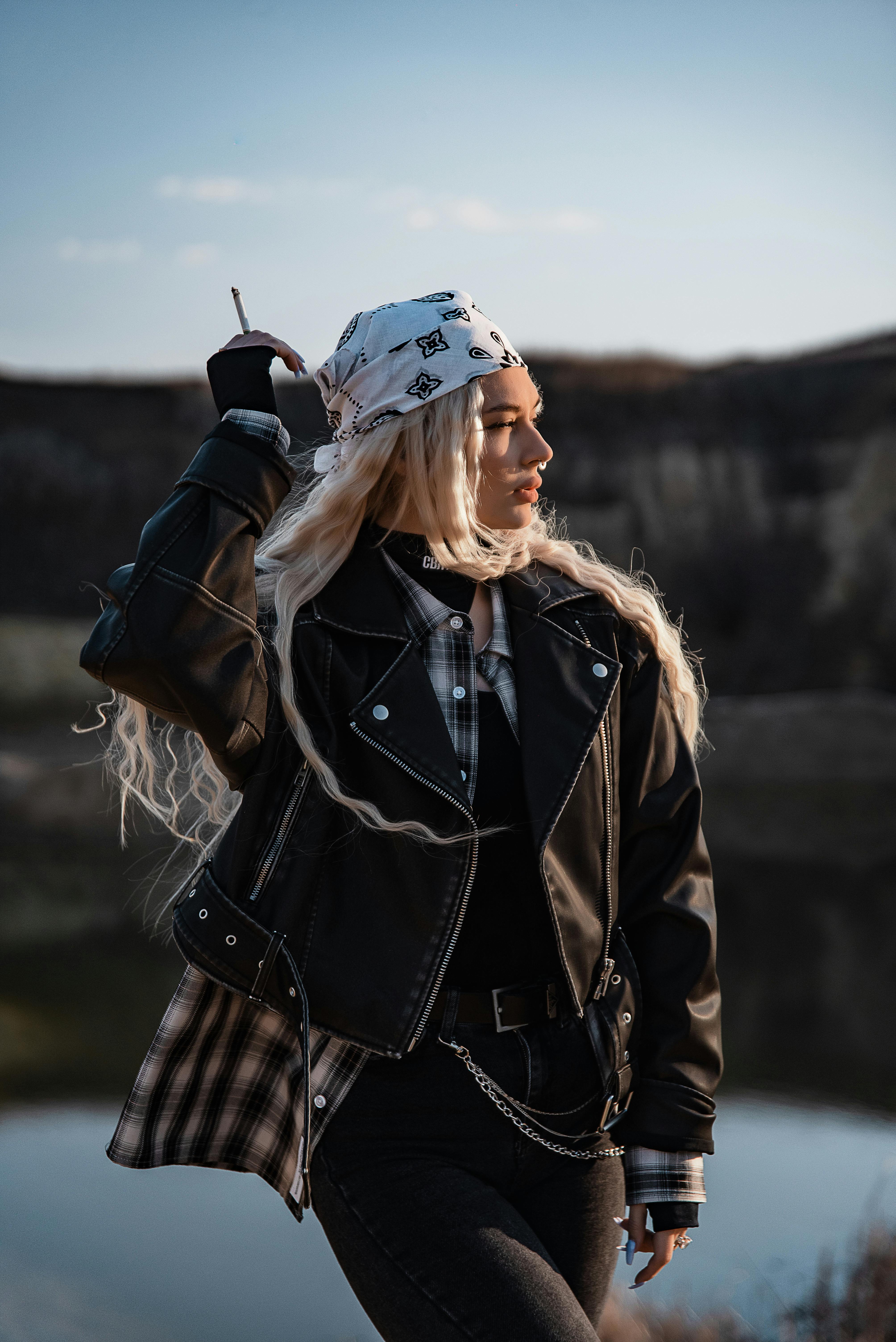 穿着皮夹克和头巾的时尚女性在户外自信地摆姿势