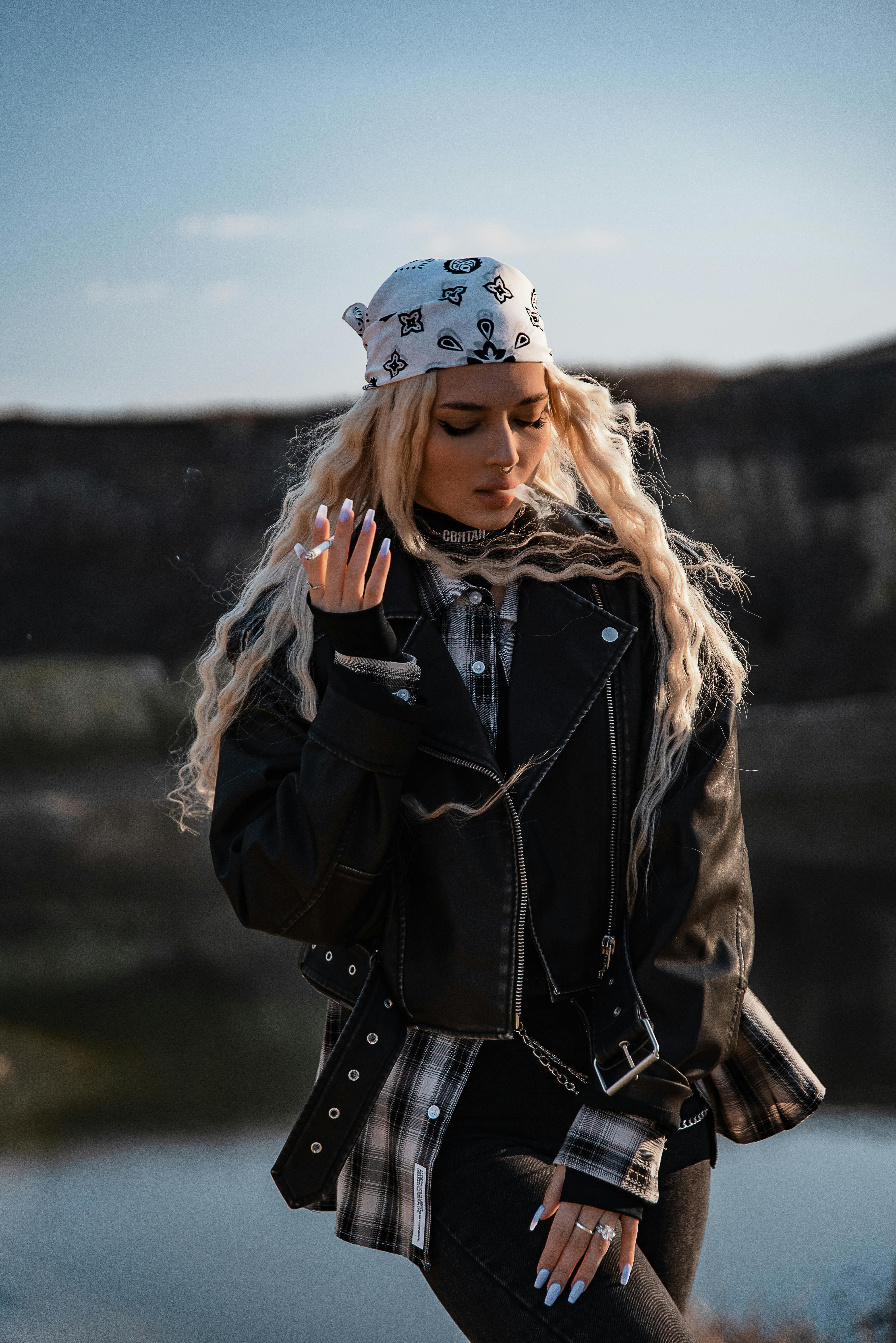 金发的时尚女子，穿着皮夹克，在户外摆姿势