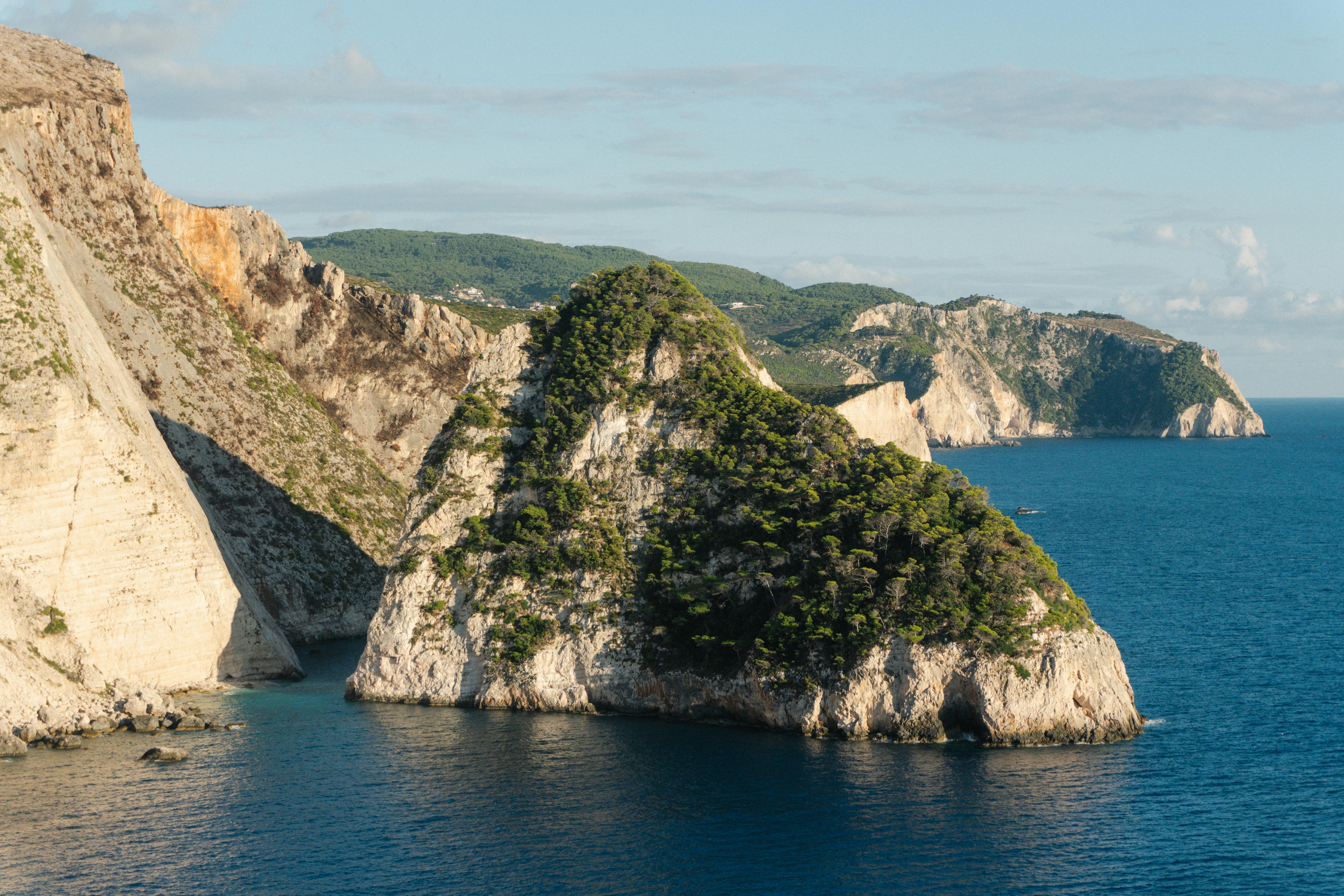 在晴朗的天空下，崎岖的沿海悬崖被蔚蓝的海洋包围，令人惊叹