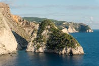 在晴朗的天空下，崎岖的沿海悬崖被蔚蓝的海洋包围，令人惊叹