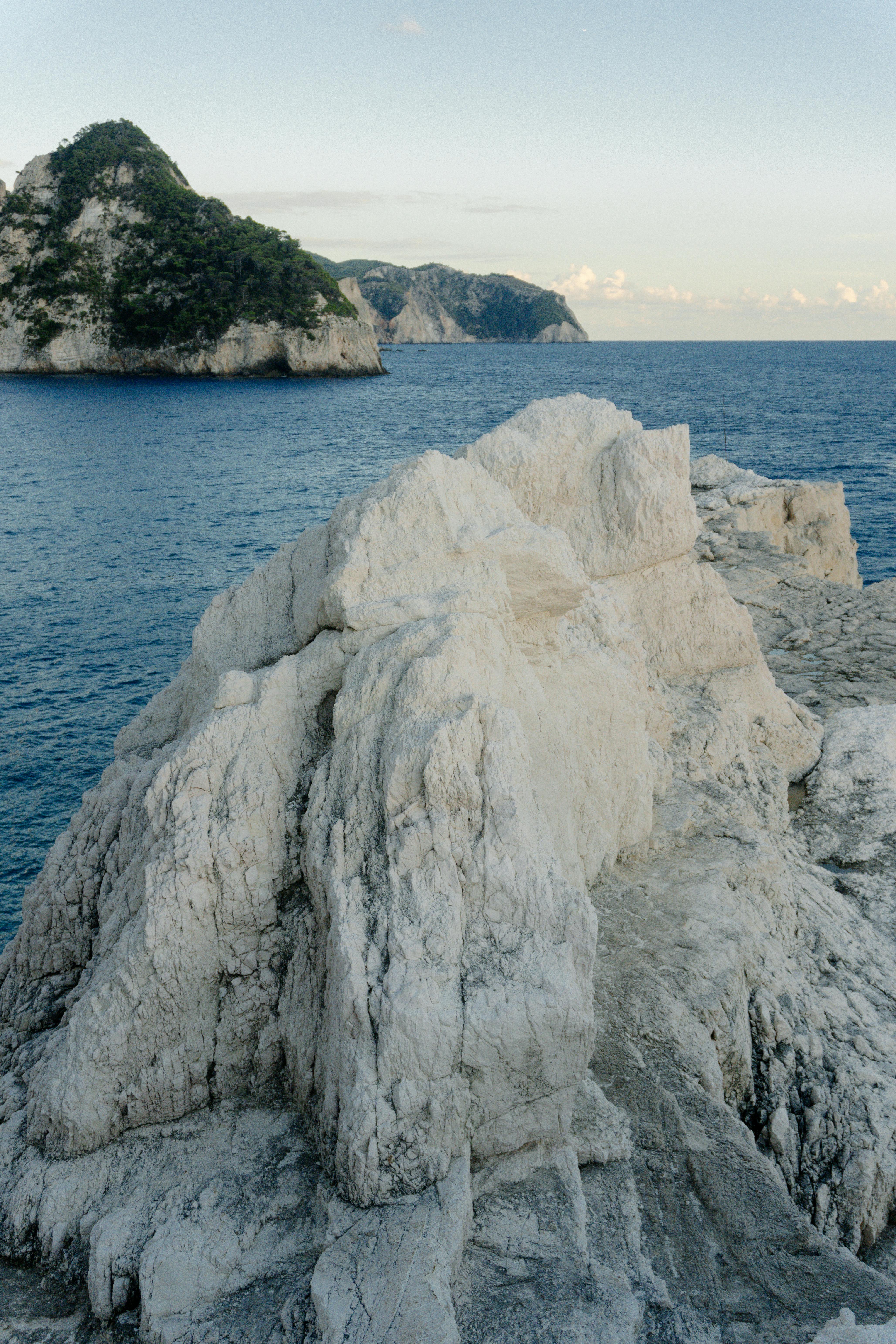 宁静的看法崎岖的沿海岩层，对平静的蓝色大海和遥远的绿色悬崖的背景
