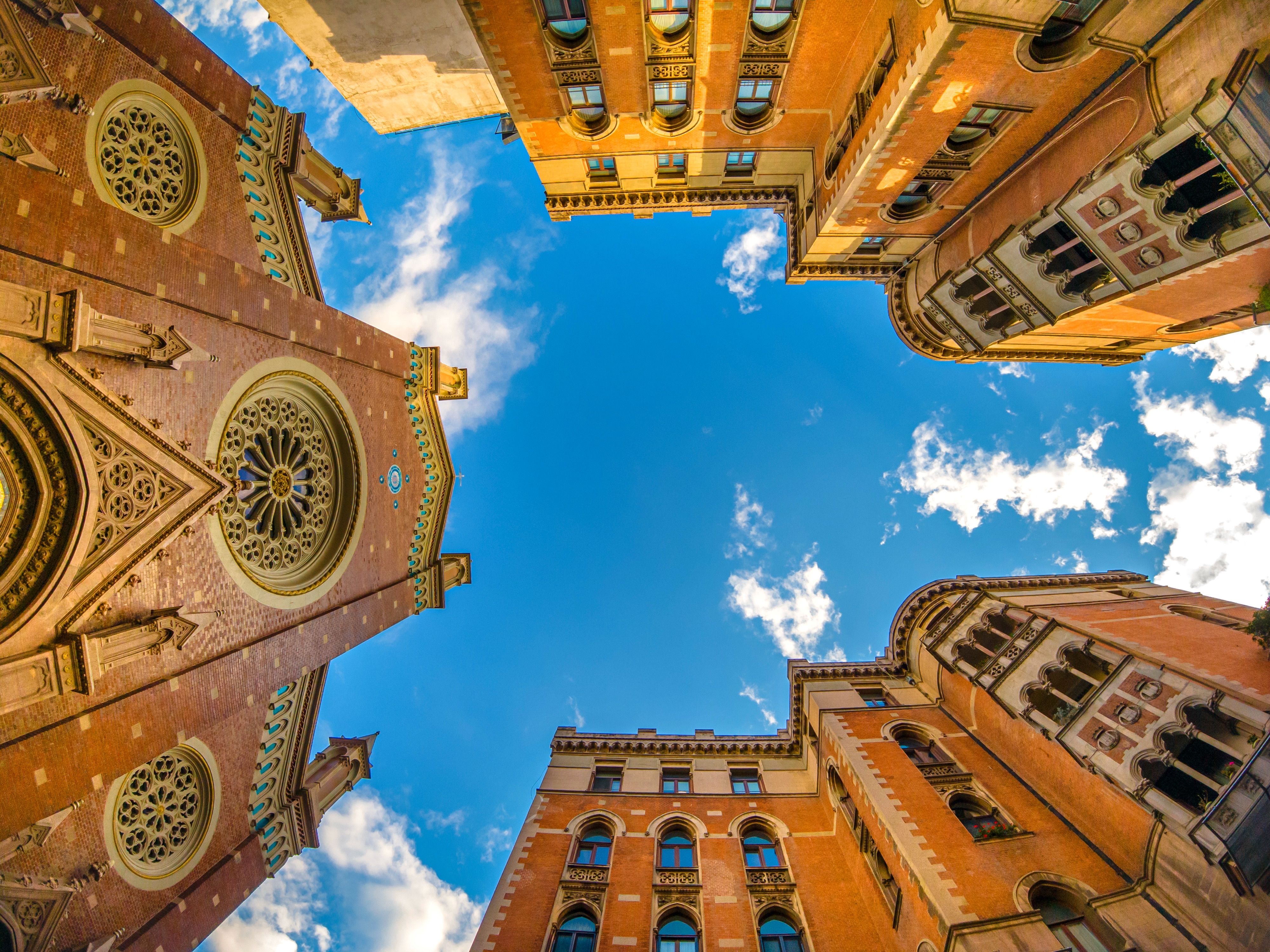 Upward View of Historic Buildings Against Blue Sky · Free Stock Photo