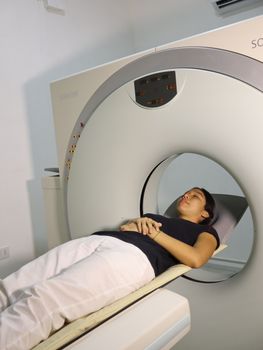 A woman lying inside an MRI machine during a medical procedure in a hospital setting.