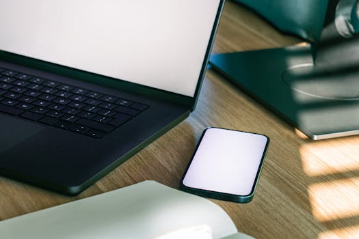 A sleek office desk setup featuring a laptop and smartphone, ideal for tech and business themes.
