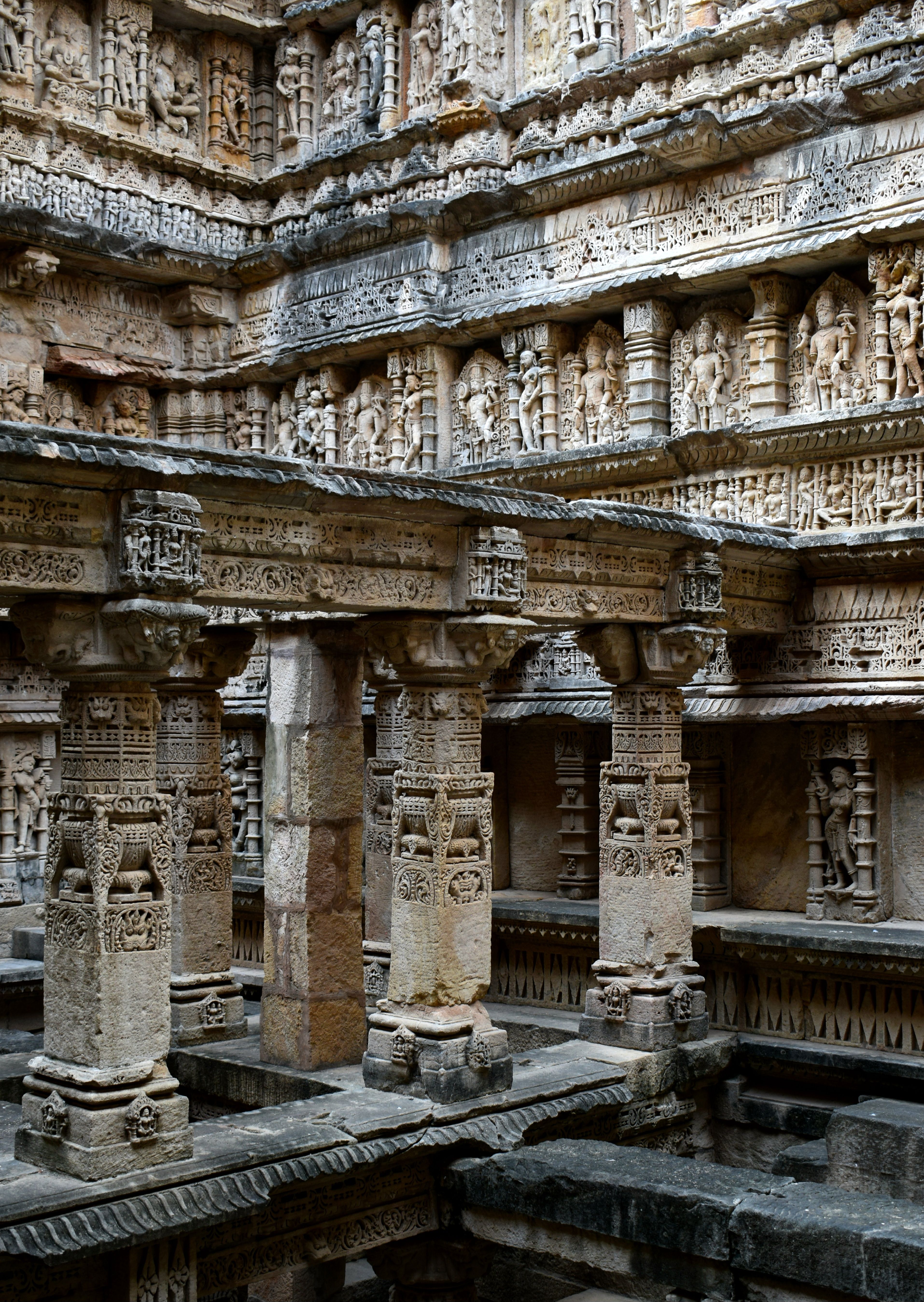 Explore the detailed stone carvings of the historic stepwell in Patan, Gujarat, India, showcasing ancient Indian architecture.