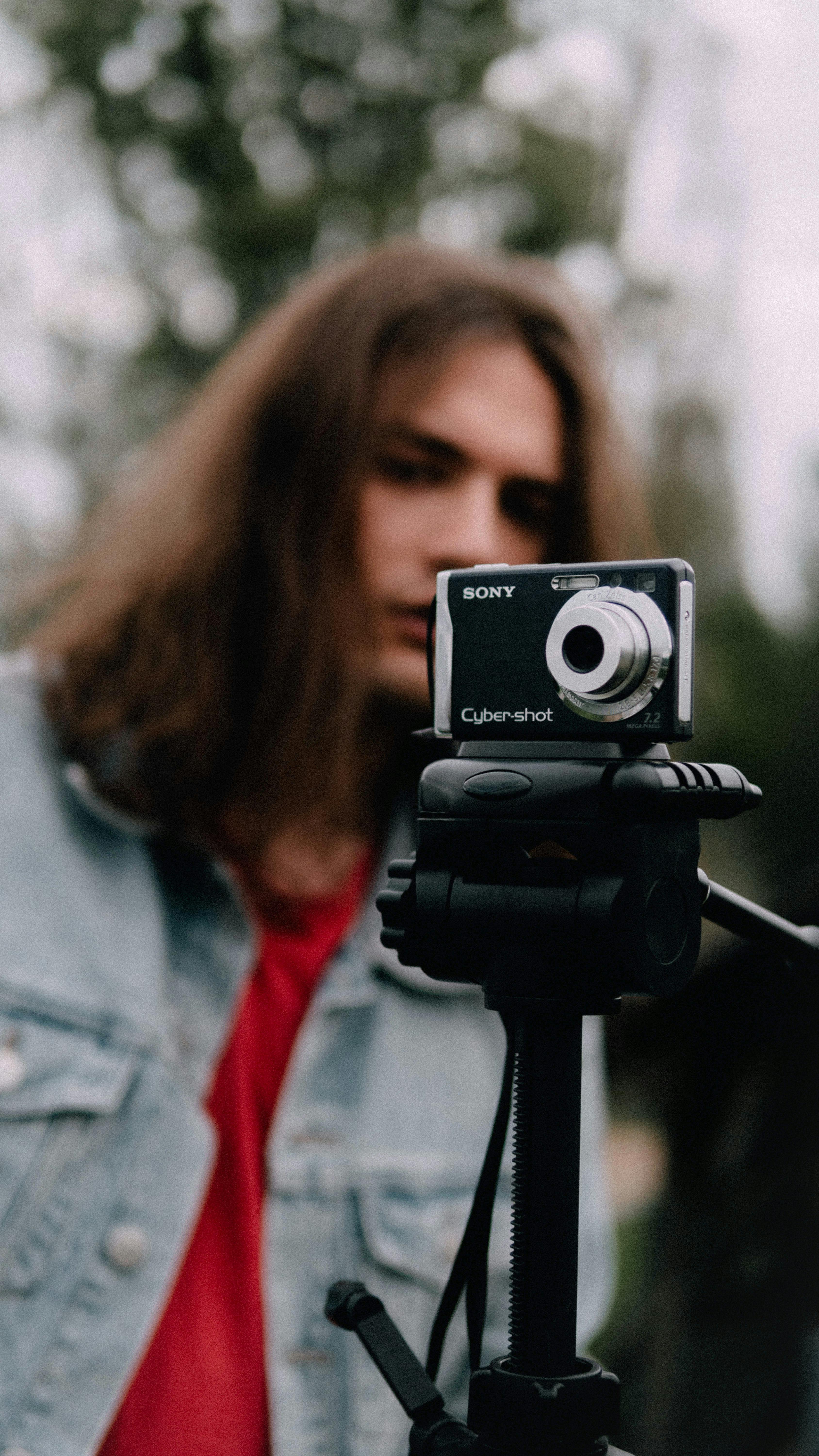 Безкоштовне Молодий дорослий знімає міську сцену за допомогою старовинної камери на штативі стокове фото