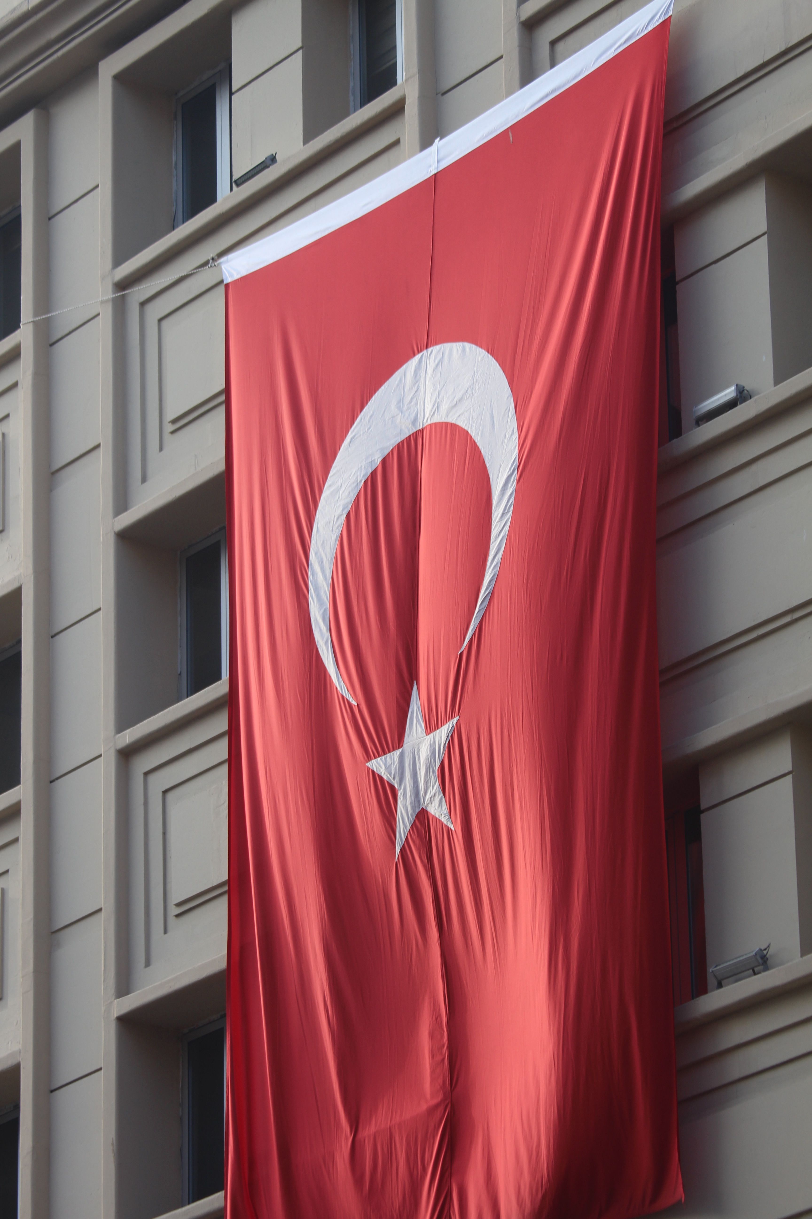 Large Turkish flag draped on a building facade, symbolizing national pride.