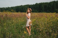 Woman in Floral Dress Standing in Sunny Meadow