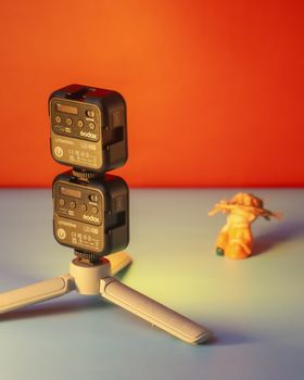Creative setup featuring camera equipment on a contrasting warm and cool background with a playful toy element.