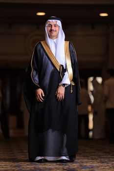 Middle Eastern man wearing traditional attire with a confident pose indoors.