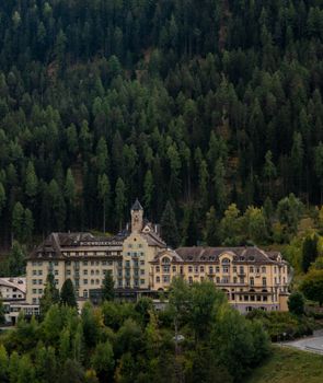 Elegant Swiss hotel nestled beside a dense forest in Scuol, Switzerland.