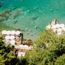 充满活力的海滩场景在空中拍摄中得以呈现，游泳者和日光浴者在清澈的蓝色大海和晴朗天气中尽情享受