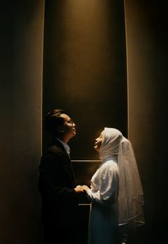 A captivating indoor portrait of a Muslim couple celebrating their wedding in Indonesia.