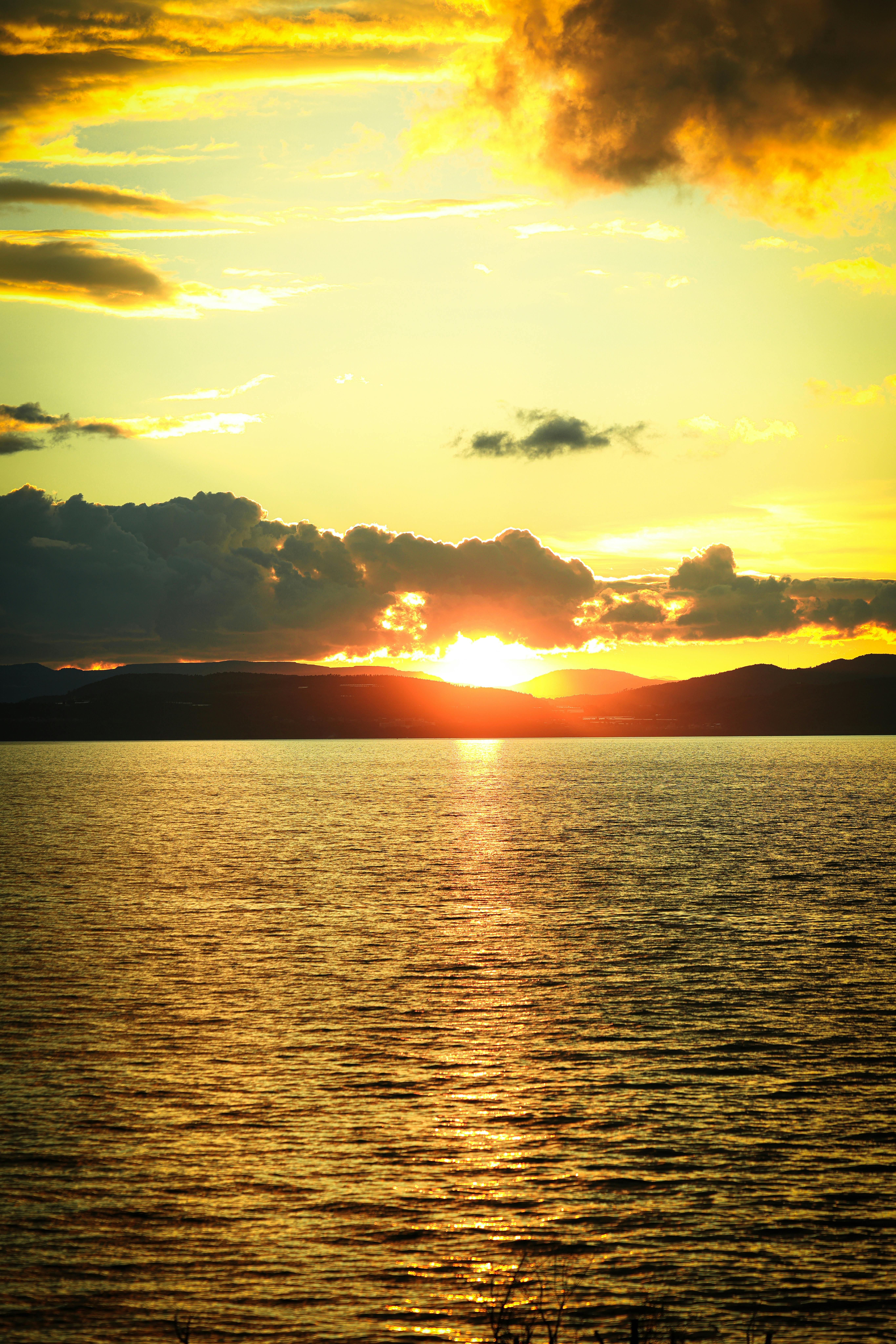 平静的水面上映照着令人惊叹的日落景象，天空中生机勃勃