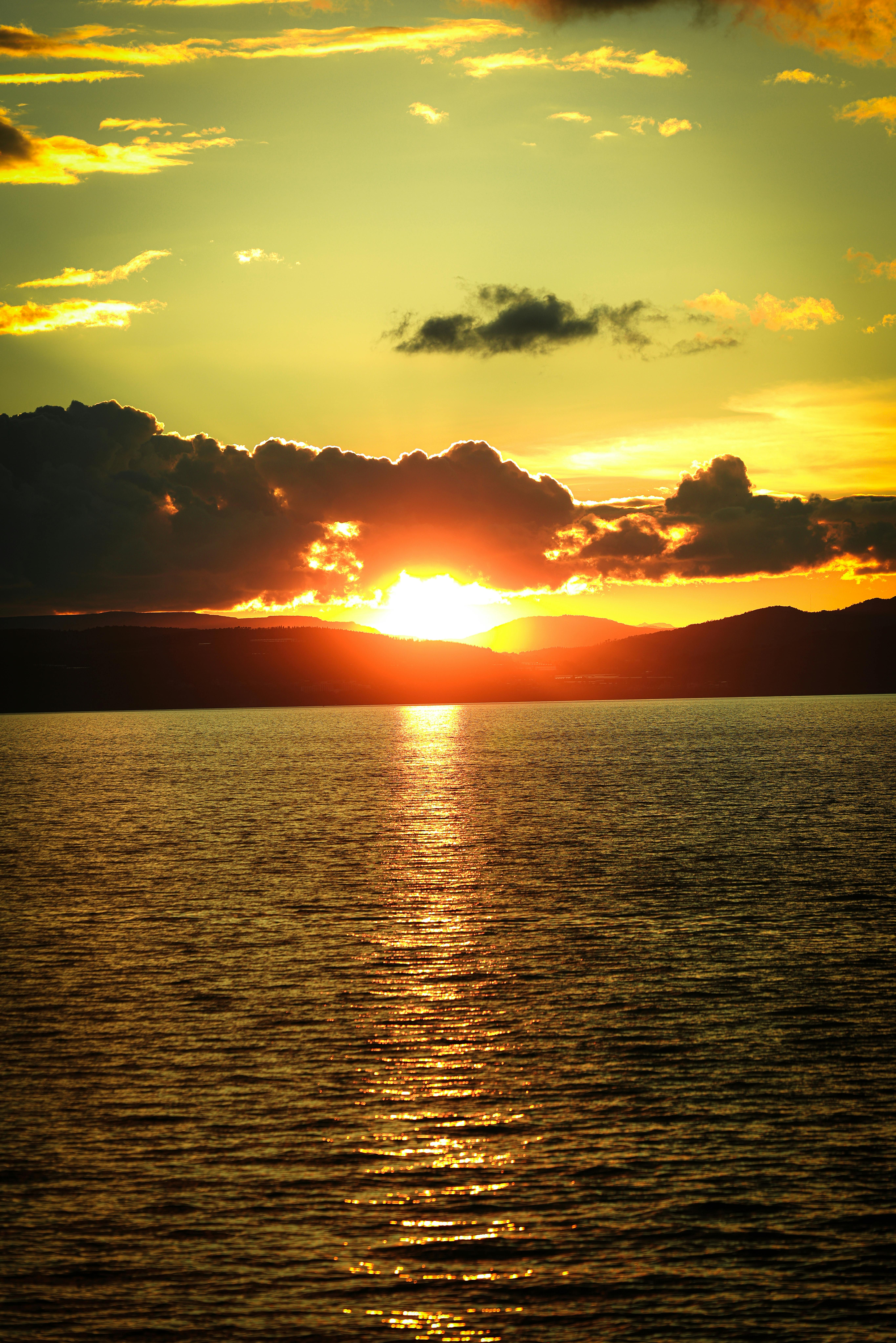 令人惊叹的日落，色彩鲜艳，倒映在平静的海浪上