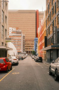 Vibrant street scene in downtown Cape Town with colorful buildings and parked cars.