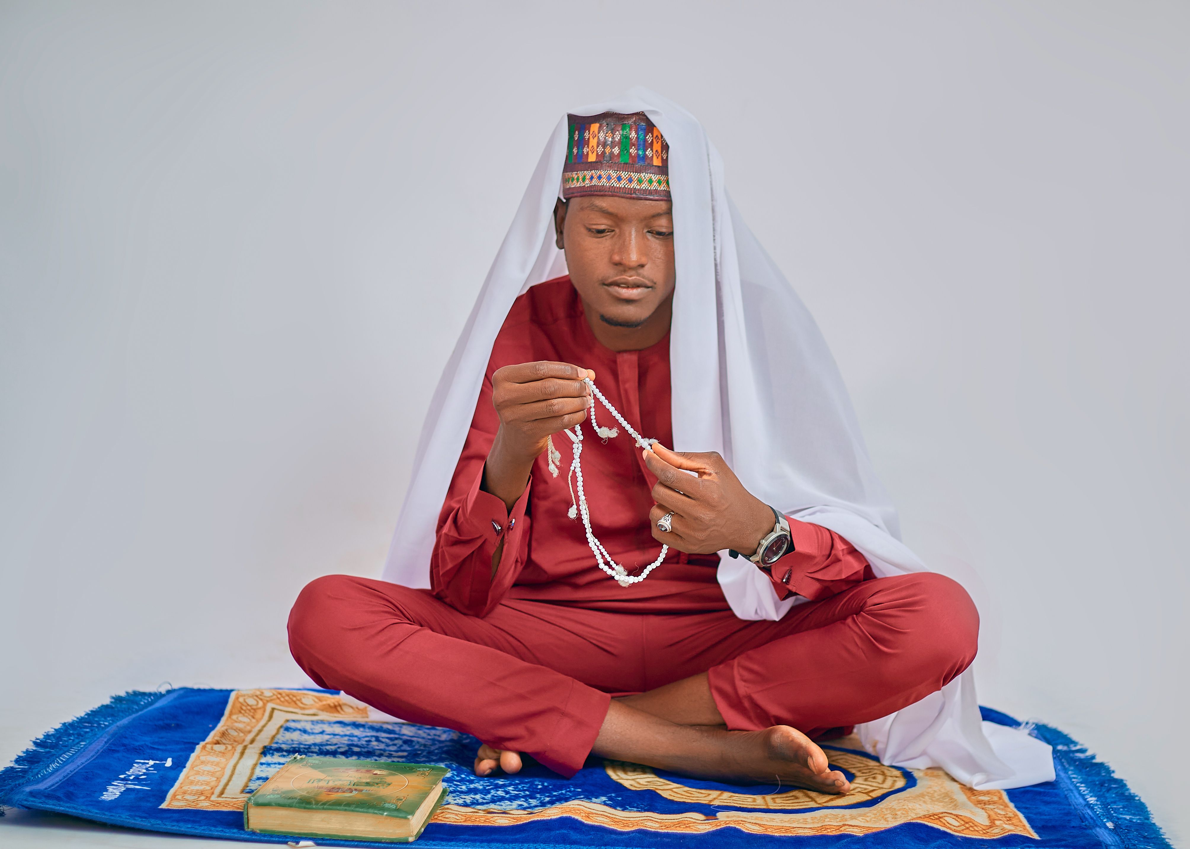 Young man in traditional attire with prayer beads · Free Stock Photo