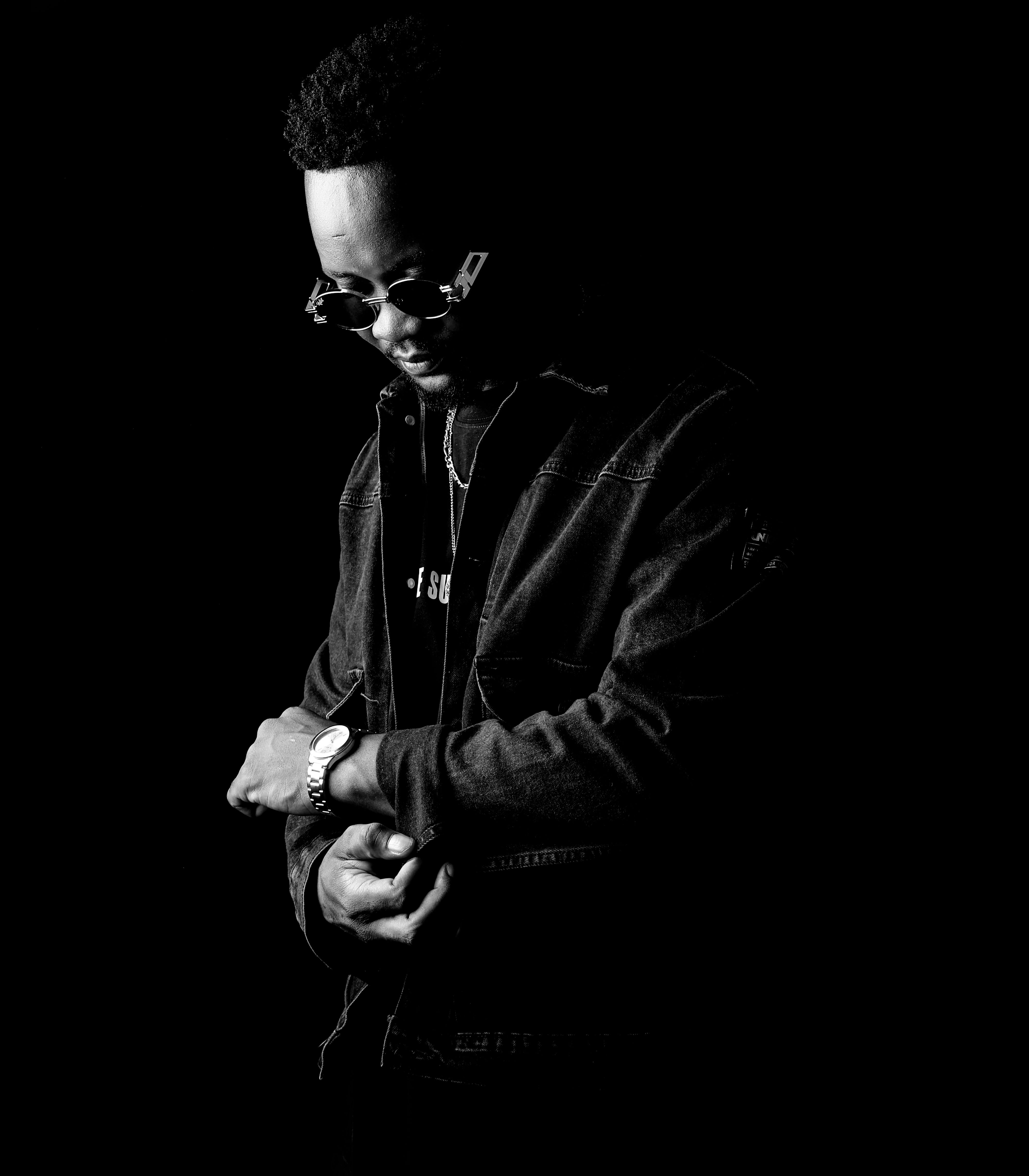 Black and white portrait of a stylish man wearing sunglasses and a watch.
