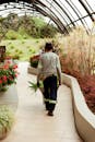 Gardener Walking Through Botanical Greenhouse