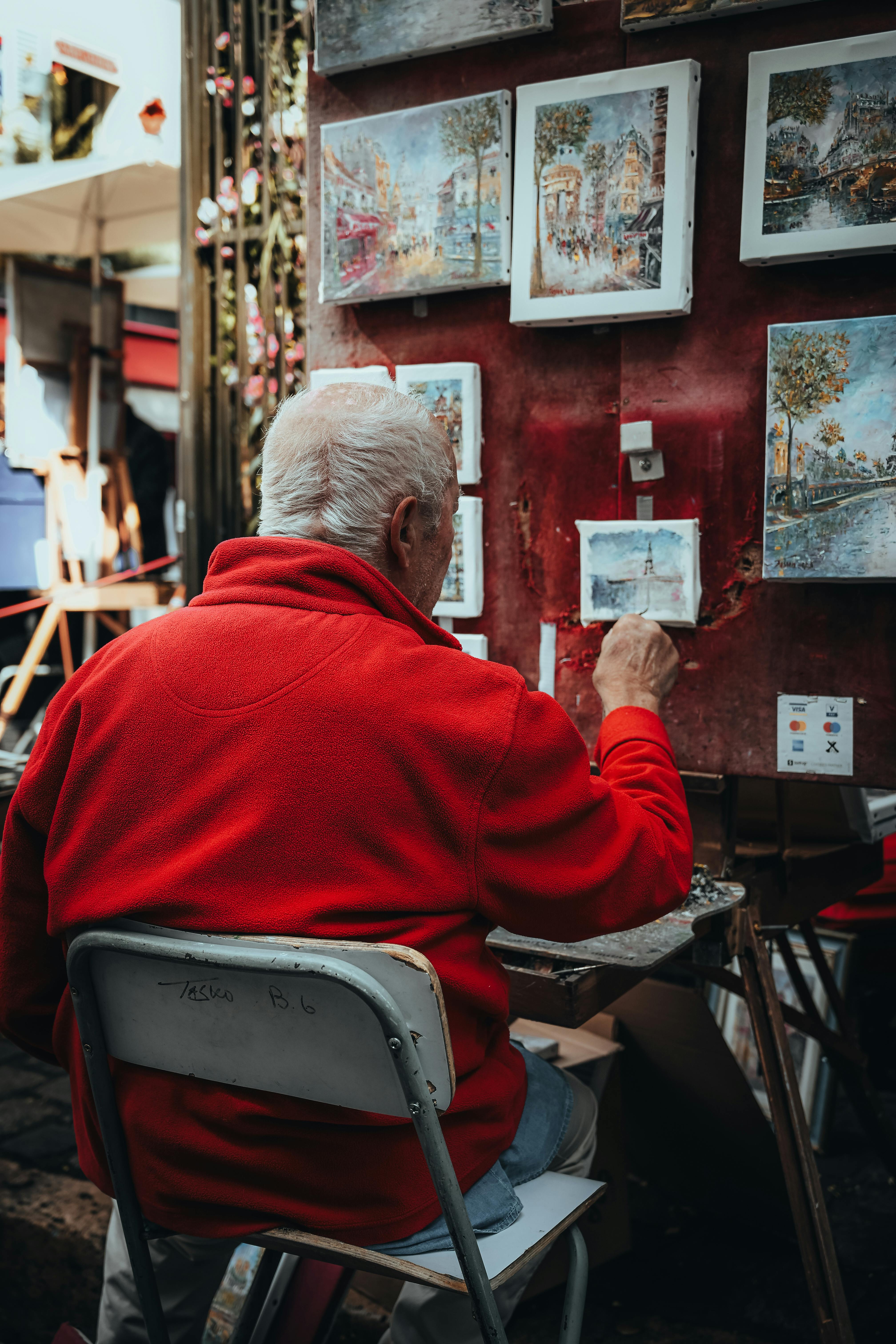 An artist in Montmartre, Paris, paints charming street scenes. Captured in vibrant detail.