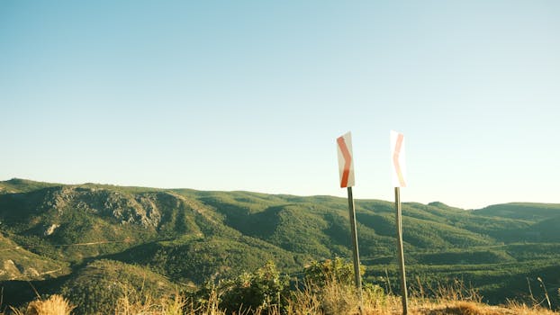 在日出时分，蔚蓝的天空下，山景和路标构成了一幅风景优美的画面