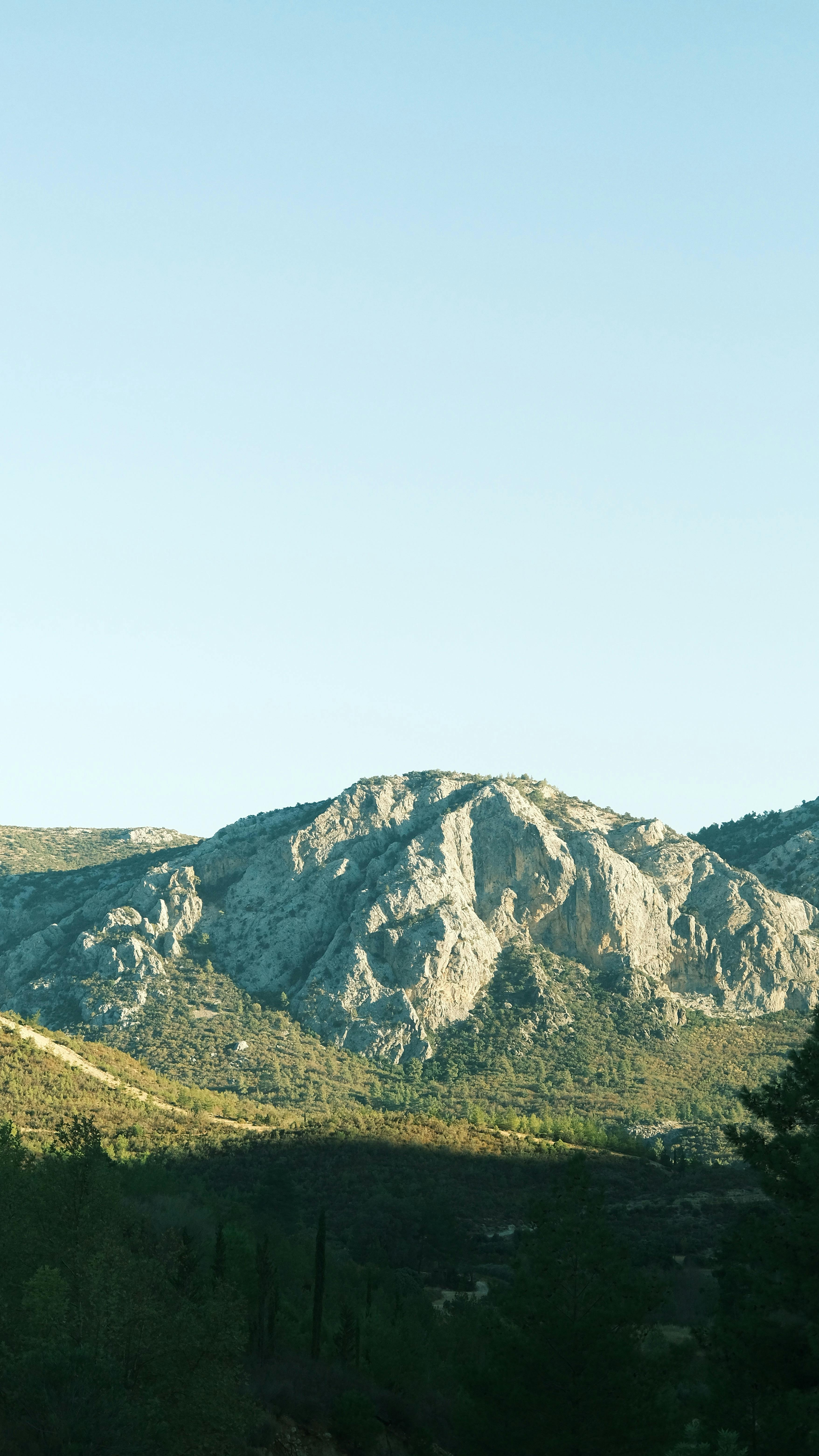 在晴朗的天空下，柔和的阳光照亮了美丽的山脉