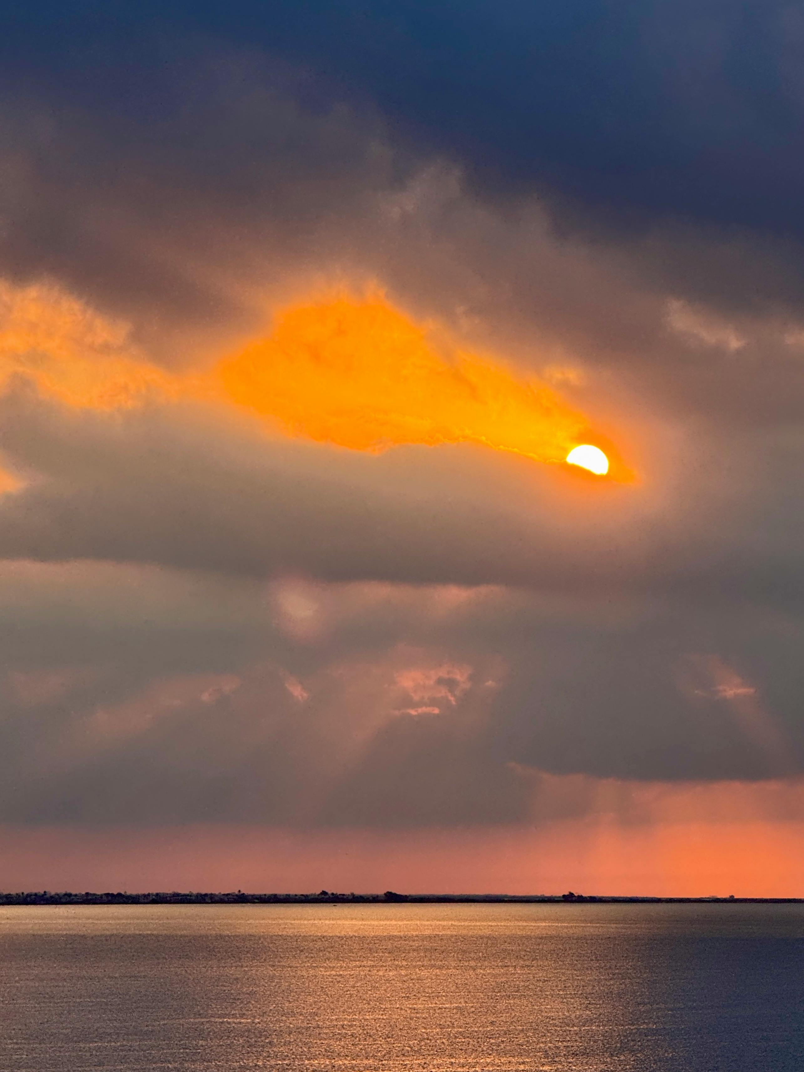 在土耳其梅尔辛附近的地中海，观赏壮丽的日落景色，天空中鲜艳的橙色云朵与平静的海水交相辉映